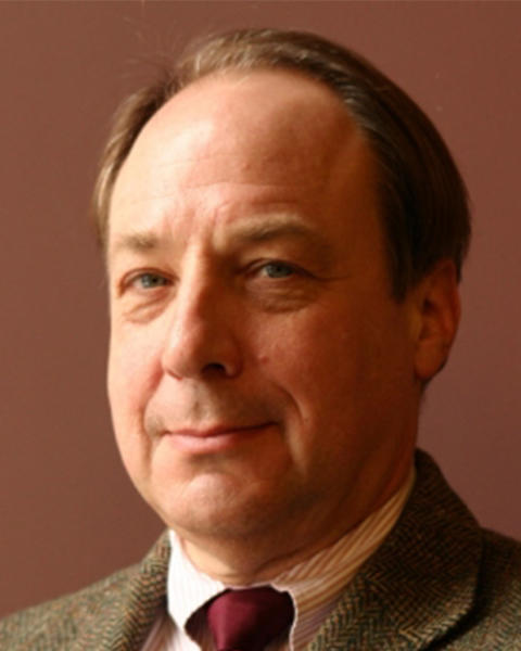 Harry R. Lewis. Headshot. Harry is wearing a shirt and tie and a tweed suit jacket and looking at the viewer from an angle. He has short light brown hair and is smiling.